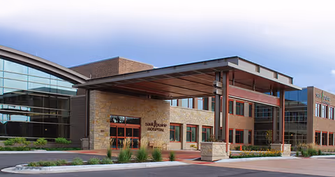 Exterior view of a modern senior living facility entrance with a covered drop-off area