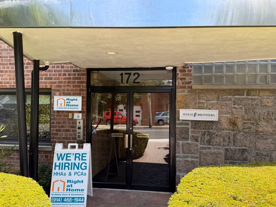 Front entrance of Right at Home facility with 'We're Hiring' sign and brick exterior, 172.