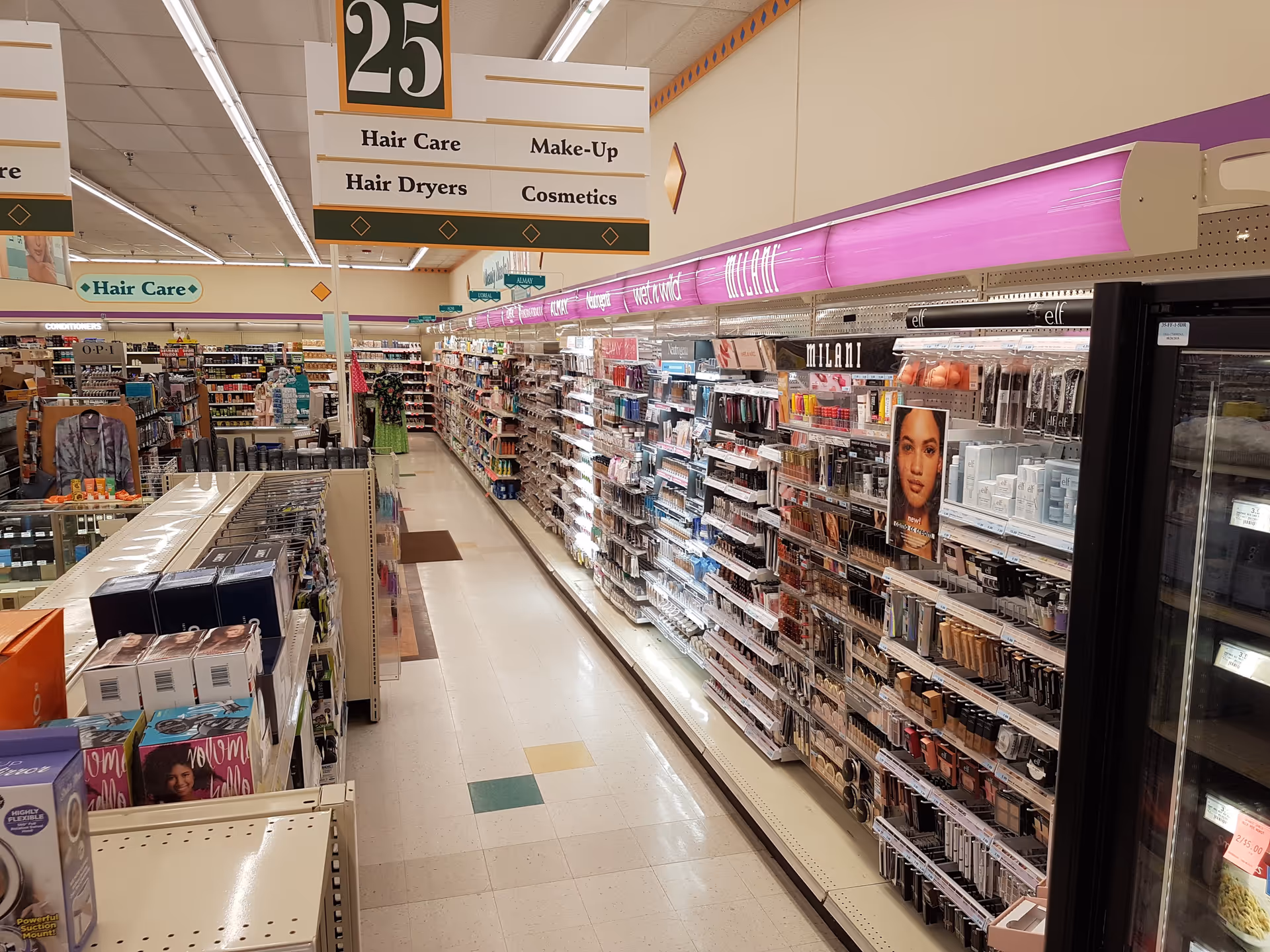 Long aisle of cosmetics, hair care, and drugstore products in Discount Drug Mart.