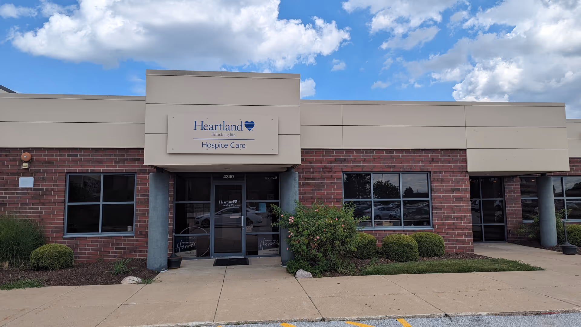 Front exterior of Heartland Hospice Care building with brick facade and entrance
