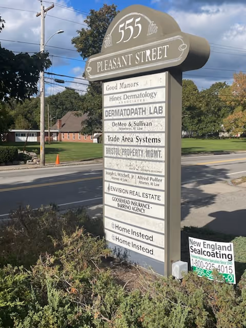 Outdoor street sign listing tenants including Home Instead at 555 Pleasant Street