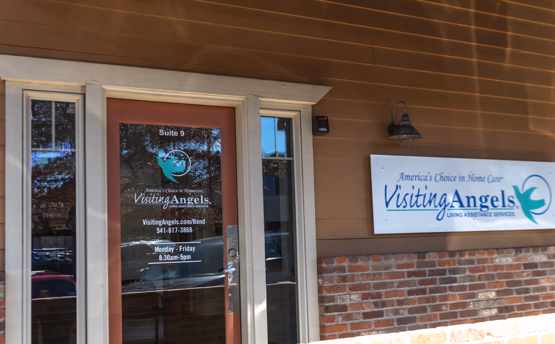 Exterior of Visiting Angels Senior Home Care storefront with door and sign.