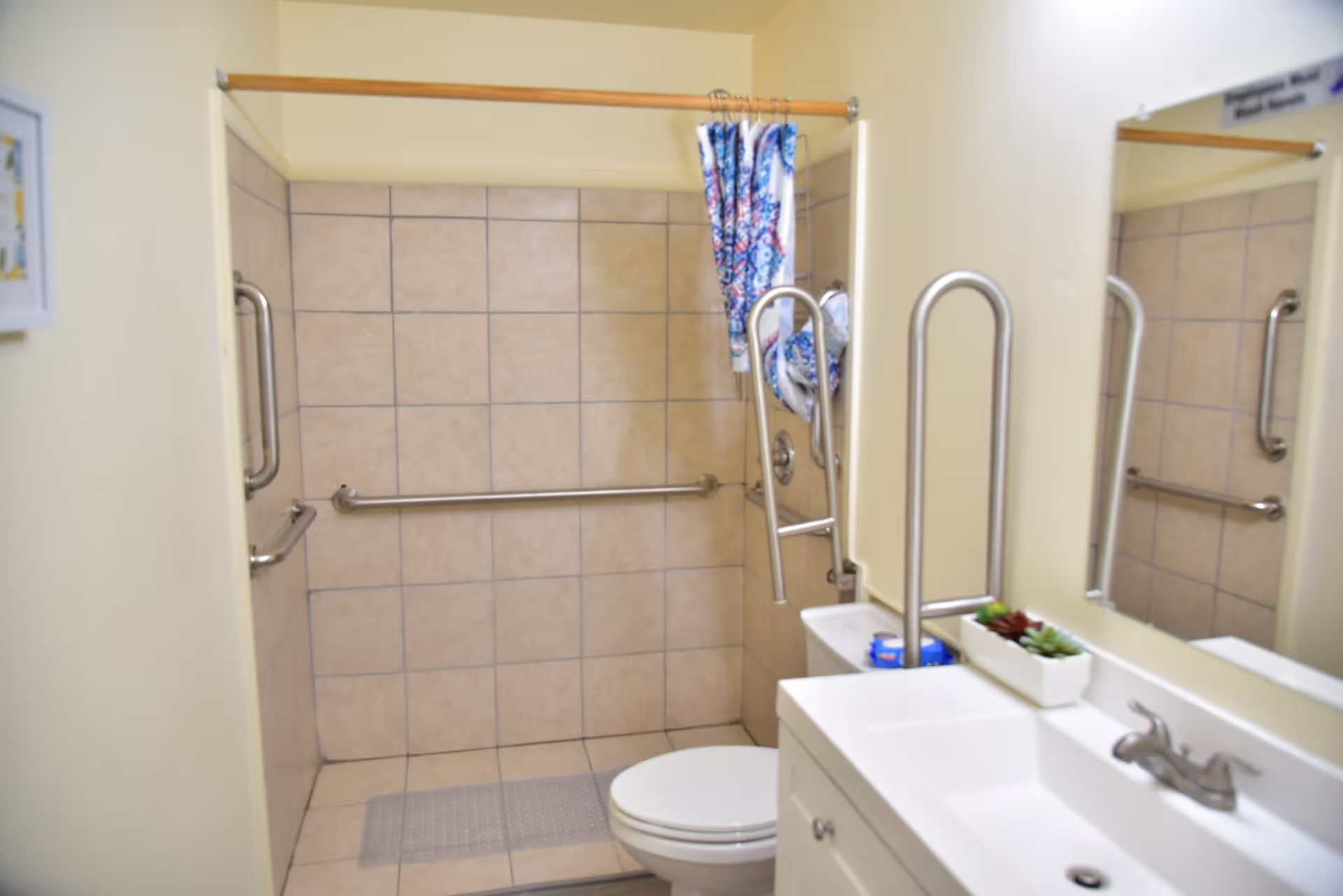 Accessible bathroom in a senior living facility with grab bars and a sink.
