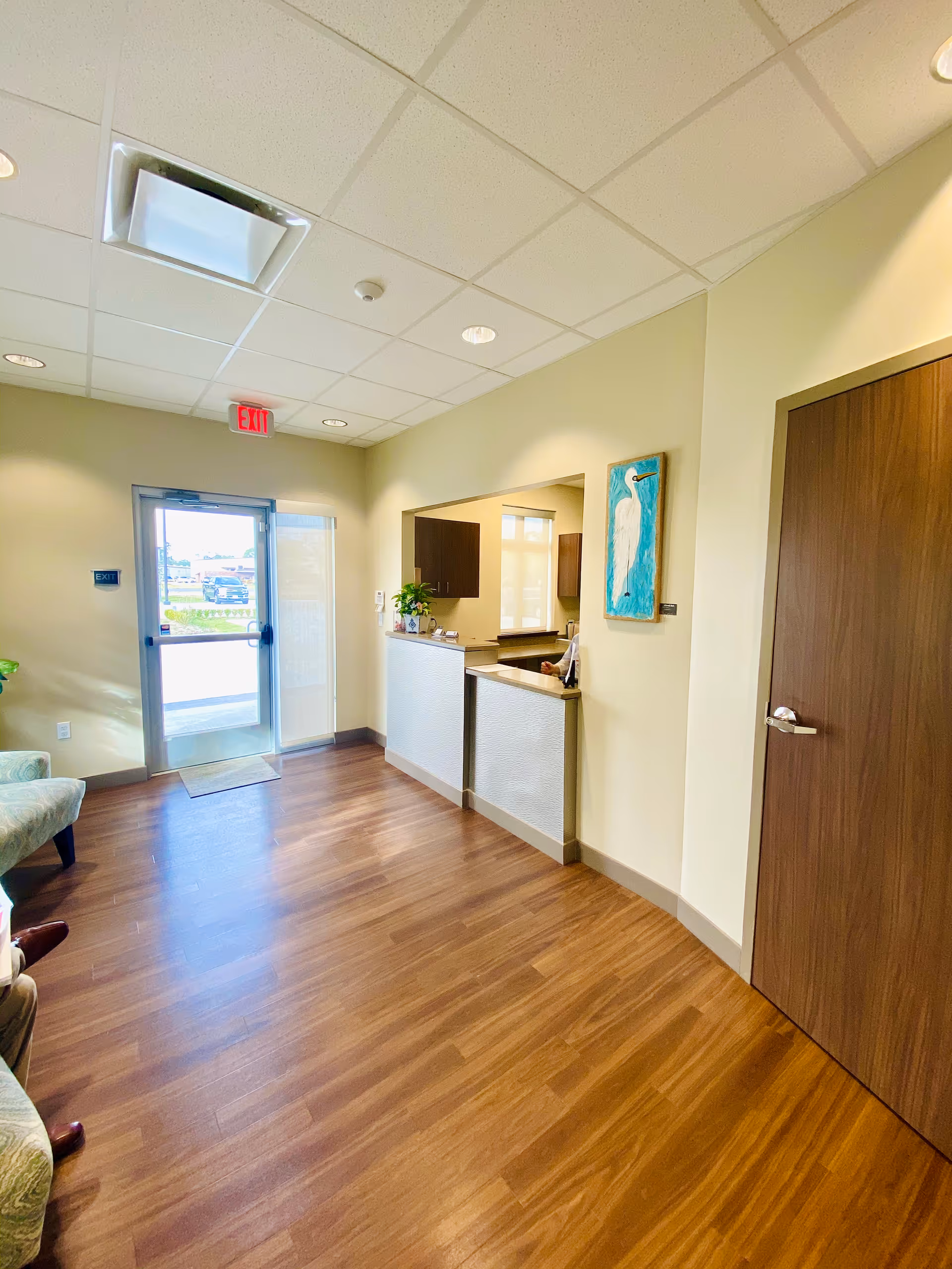 Reception area inside a senior living facility with a front desk and doorway.