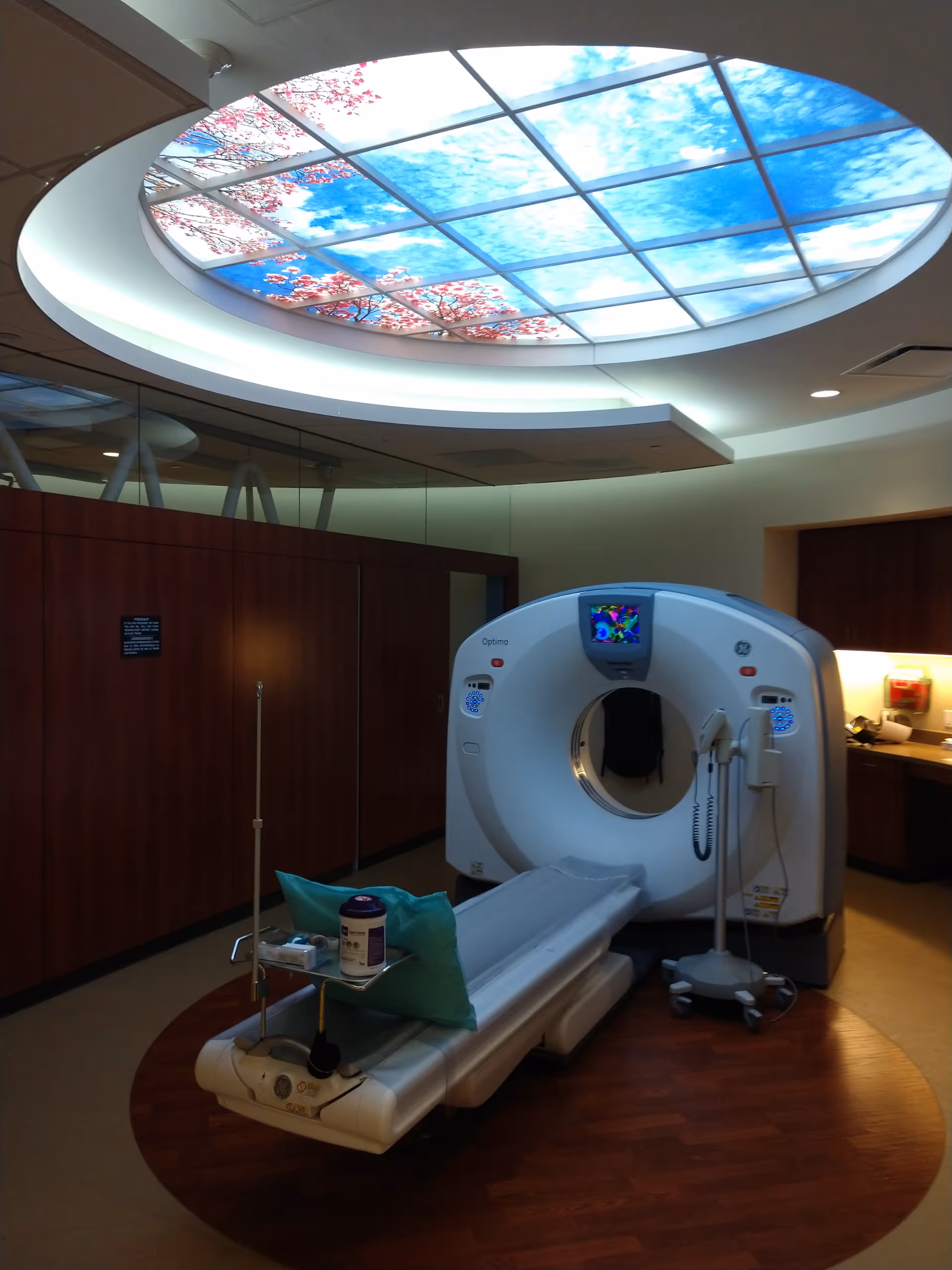 Hospital imaging room featuring a circular CT scanner and a skylight ceiling.
