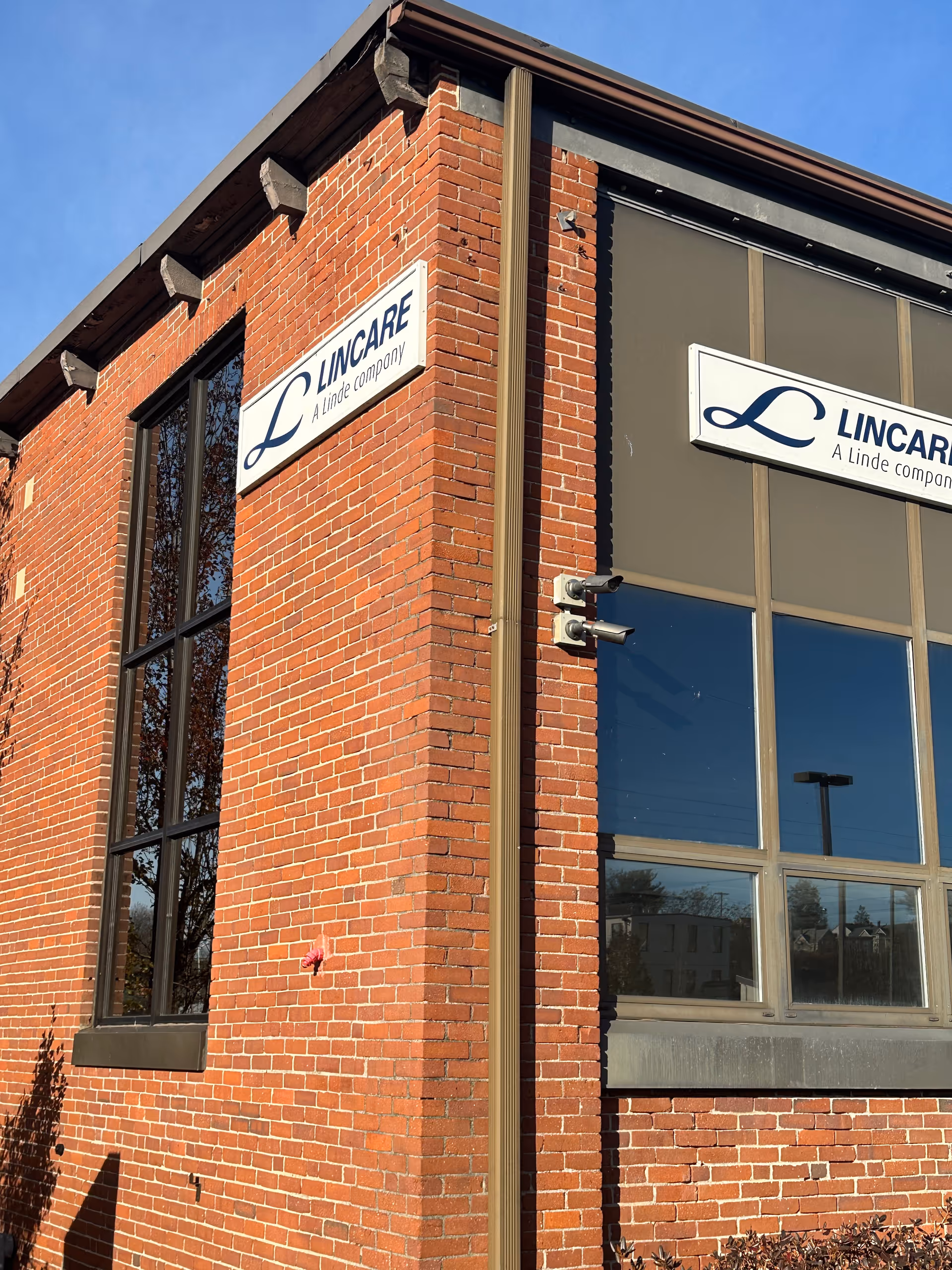 Brick exterior corner of a LINCARE facility with large windows and signage