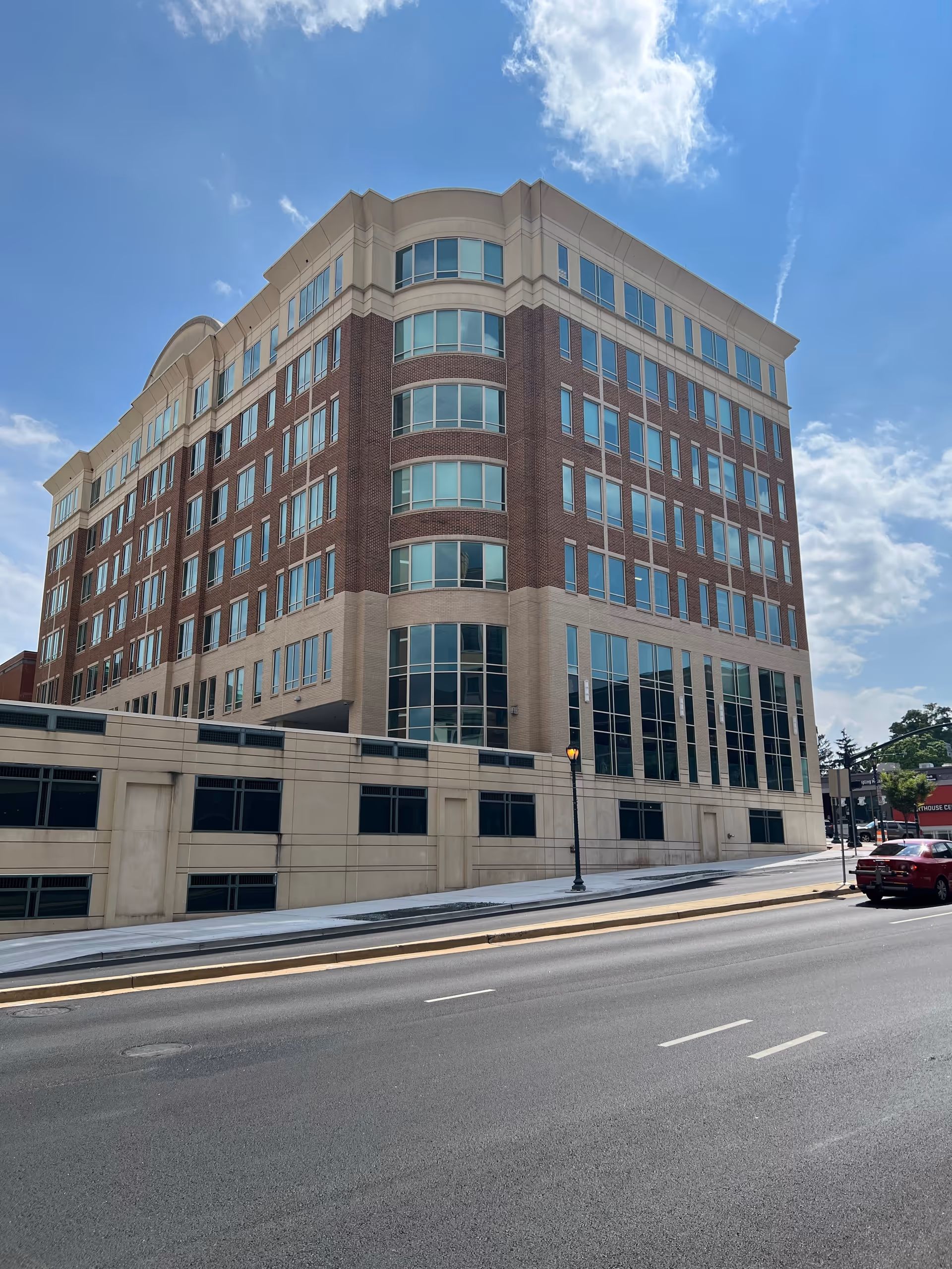 Exterior view of a tall brick senior living facility on a city street.