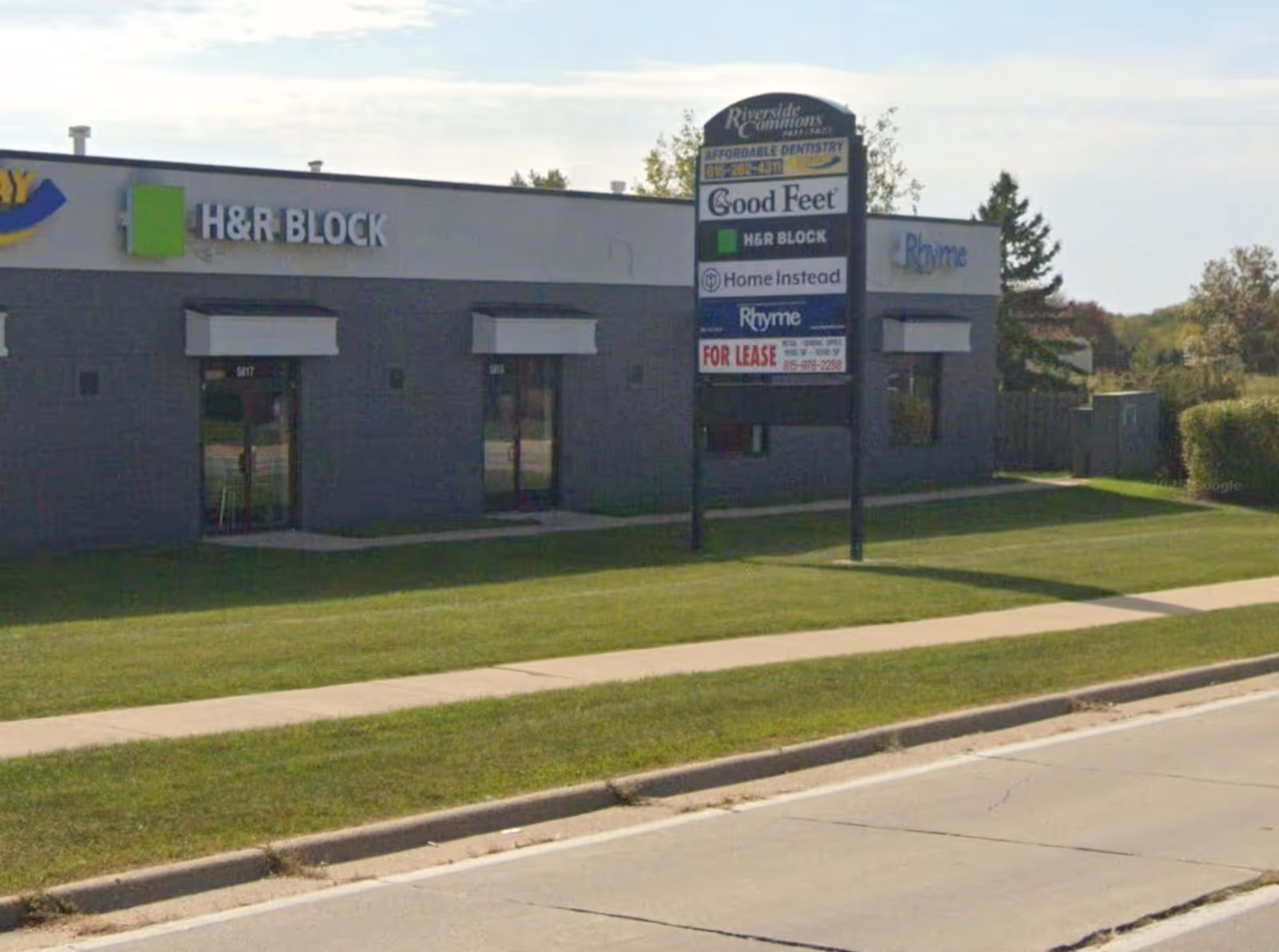 Exterior view of a single-story commercial building with Home Instead storefront and tenant signs.
