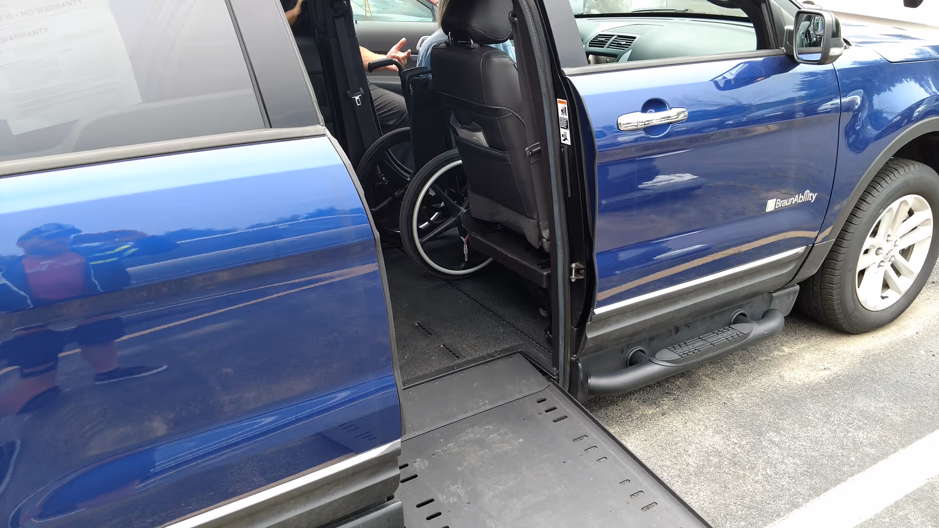 Blue mobility van with a wheelchair inside and an open side door