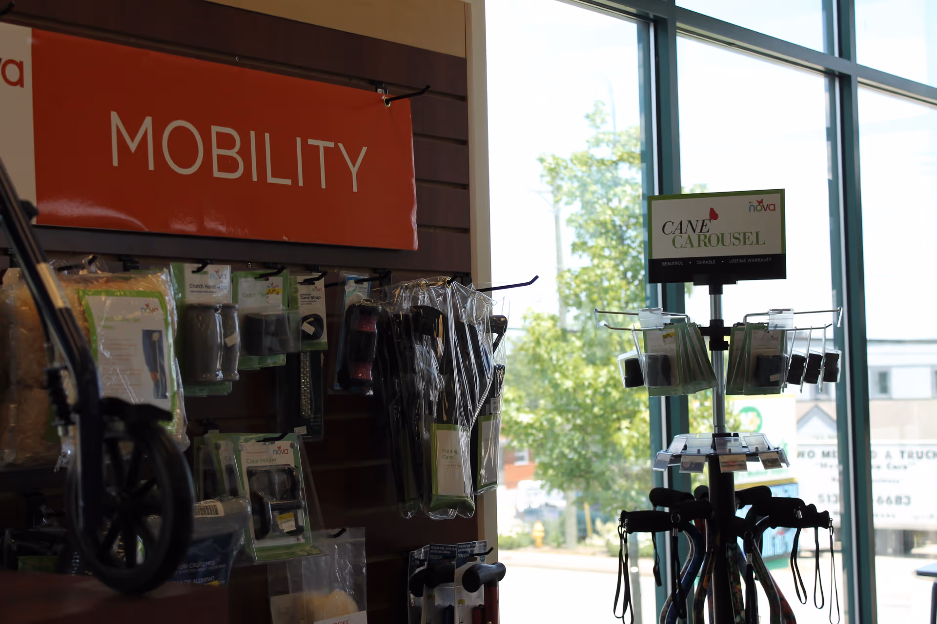 Indoor mobility-aid display with canes and accessories beside a large window.