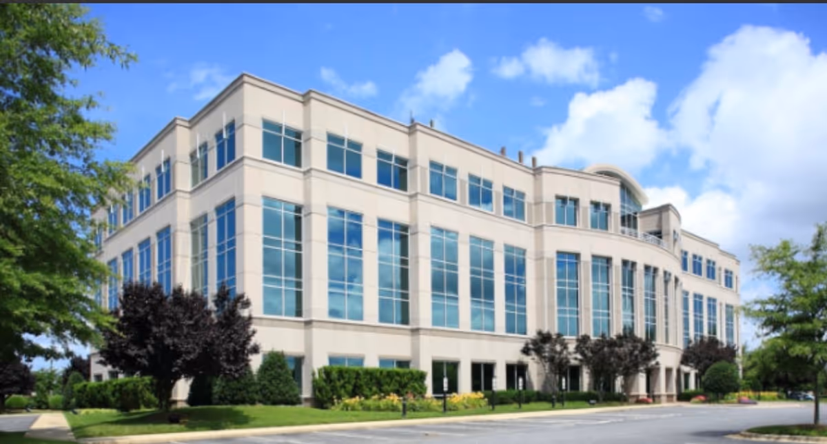 Exterior view of Amada Senior Care facility, a modern beige building with many large windows.