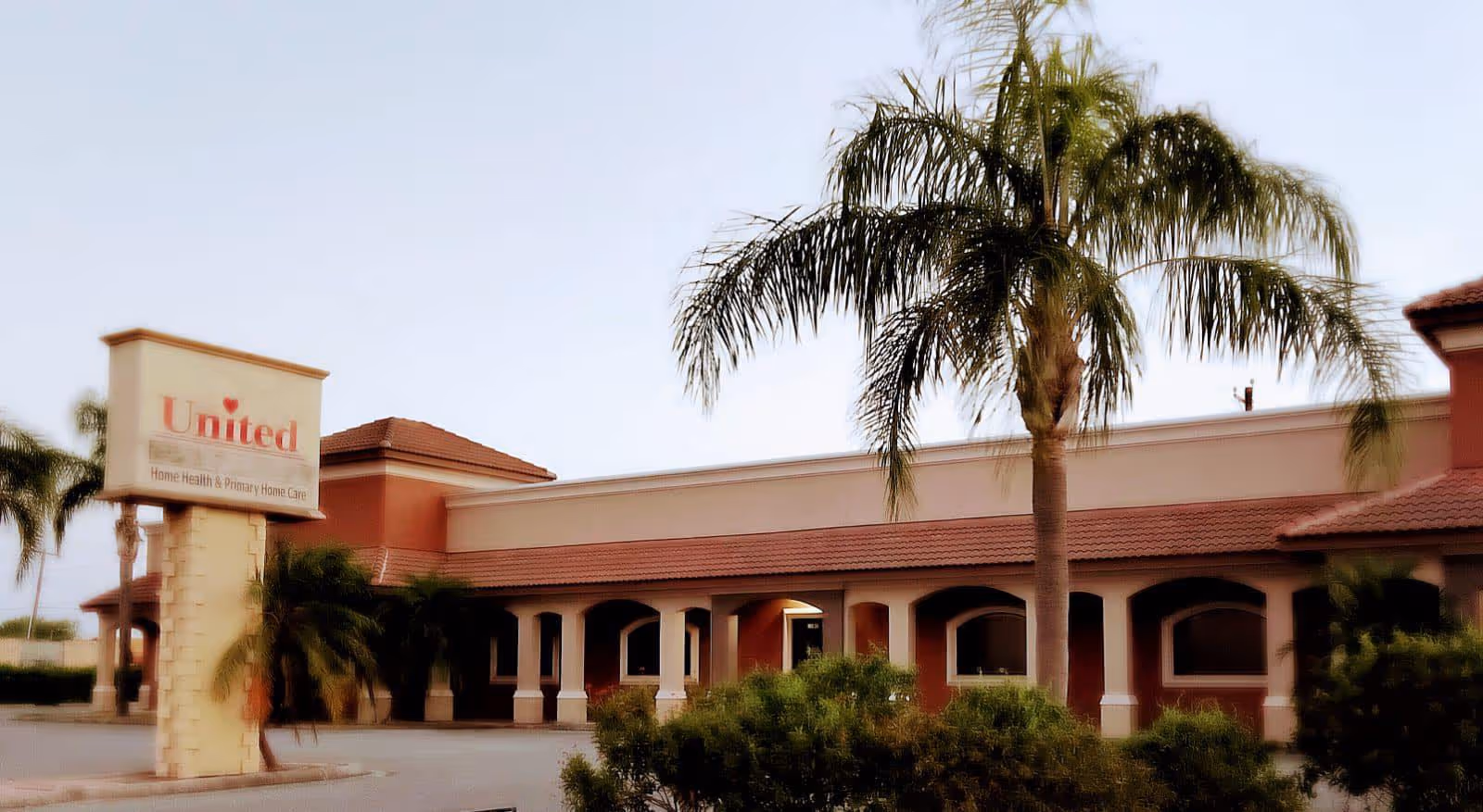 Exterior view of United Home Care facility with palm trees and front signage.