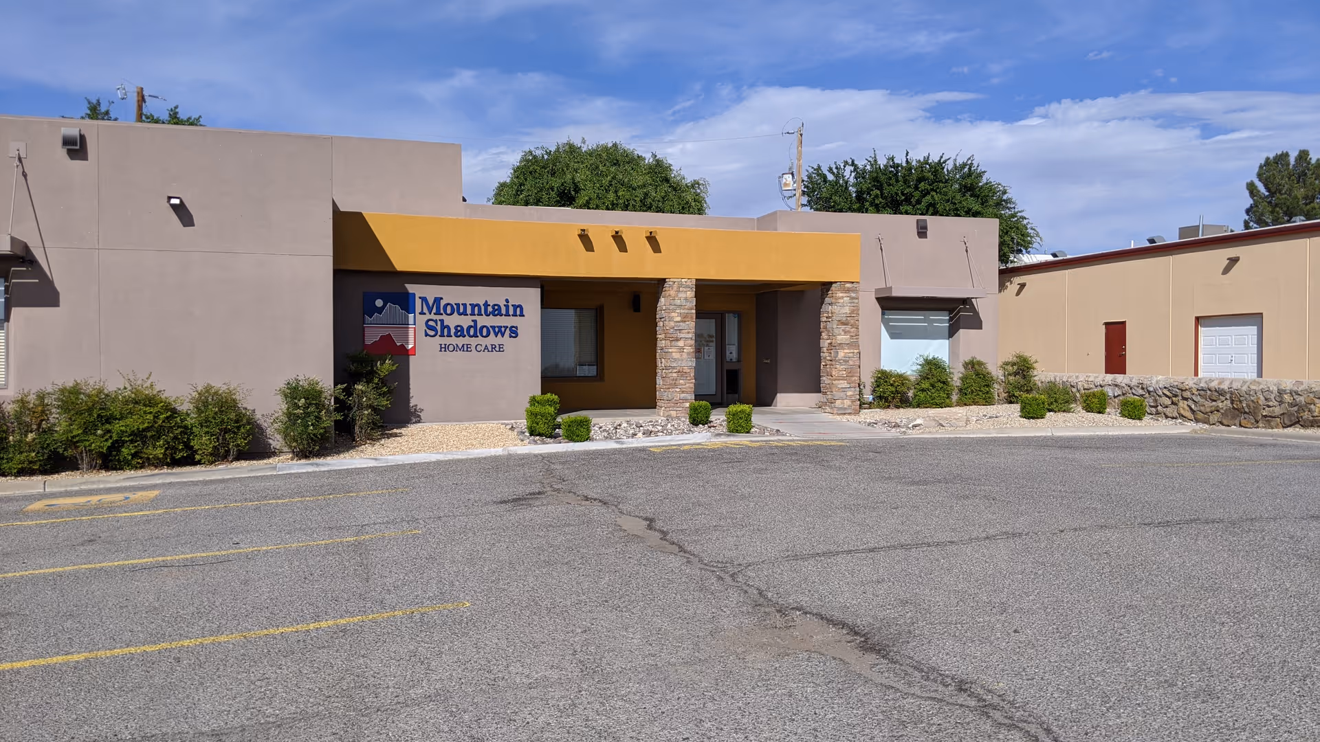 Front exterior of Mountain Shadows Home Care facility with sign and parking area.