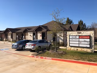 Exterior view of Enhabit Home Health facility with parked cars