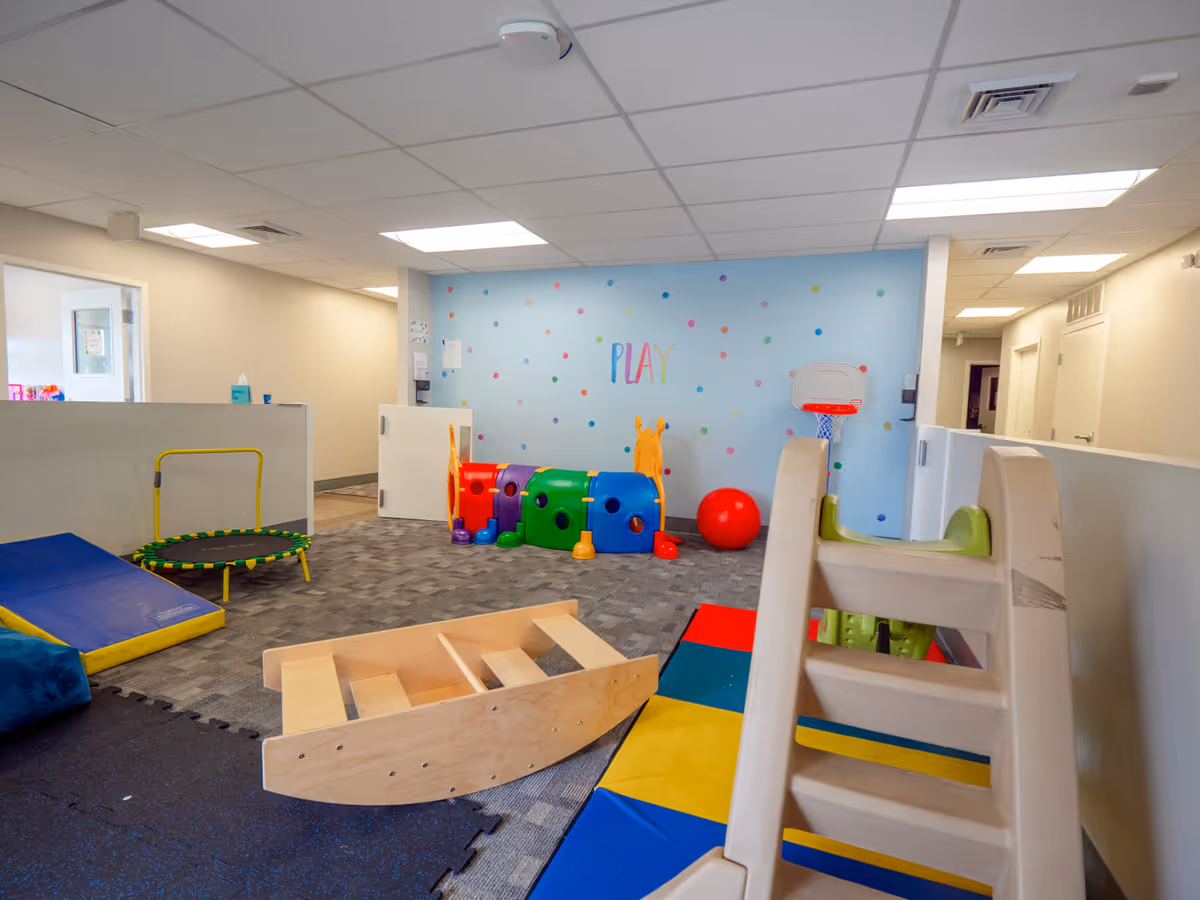 Bright indoor playroom in a senior living facility with colorful toys.