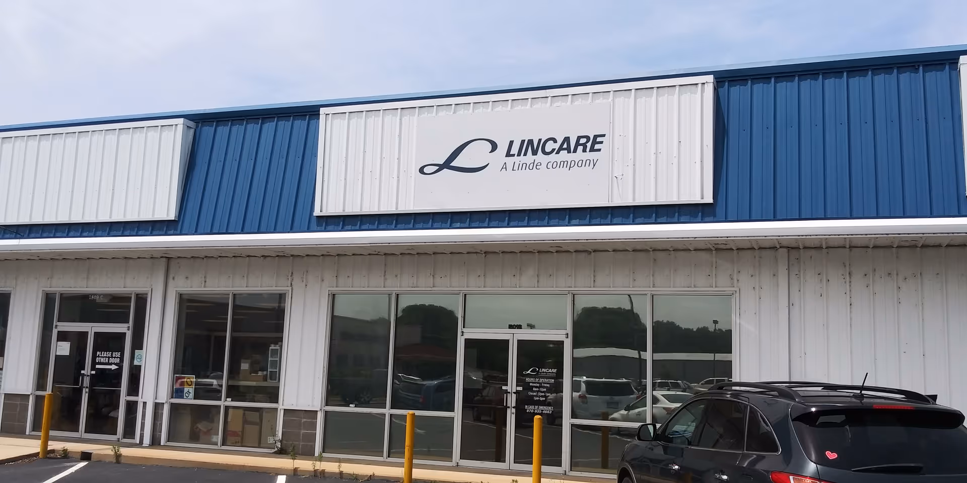 Exterior of a Lincare storefront with blue and white panels and a parked car.