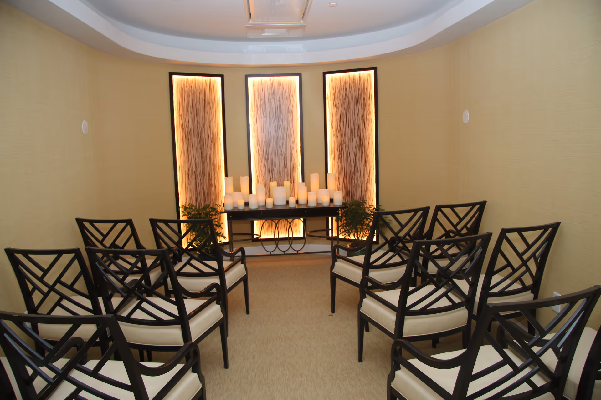 Chairs arranged in a small chapel-style room facing a lit altar with candles.