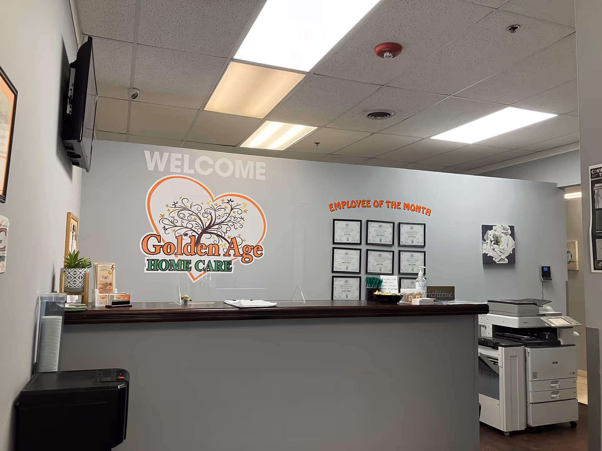 Reception area with Welcome sign and Golden Age Home Care logo on a gray wall.