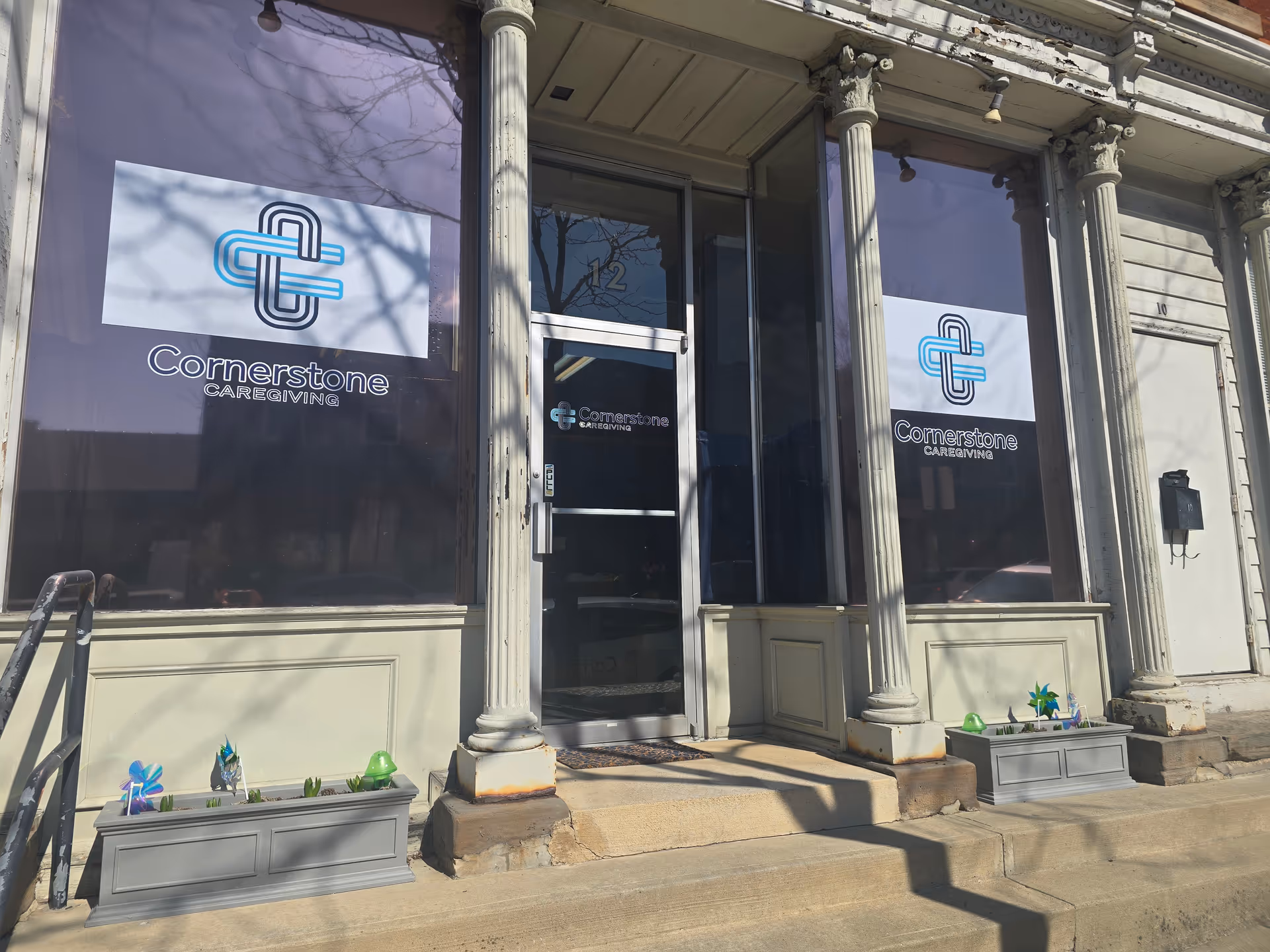 Front exterior of Cornerstone Caregiving storefront with logo banners and columns.