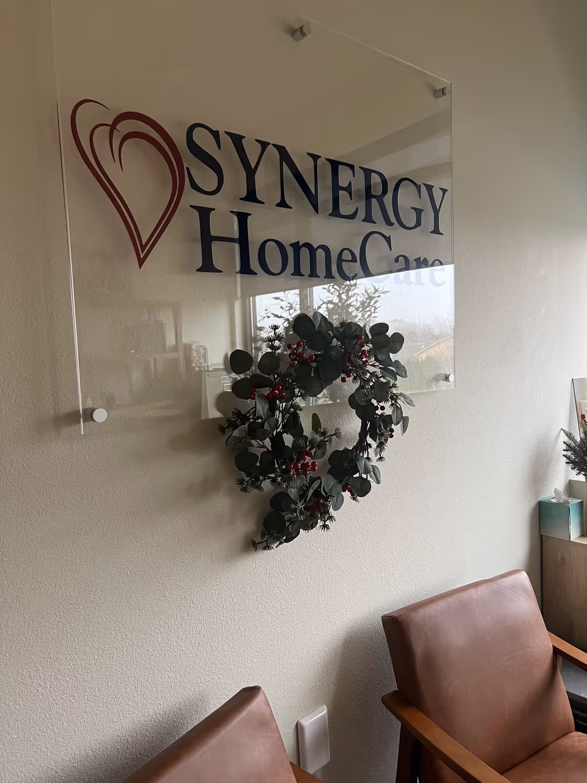 Reception area featuring a SYNERGY HomeCare sign and wreath on the wall.