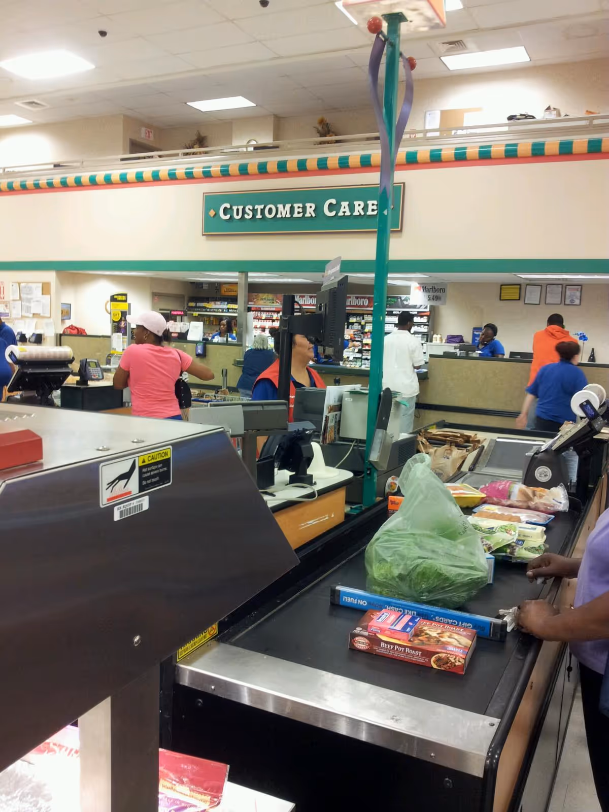 Busy Kroger checkout area with customers and cashier lanes at the pharmacy counter.