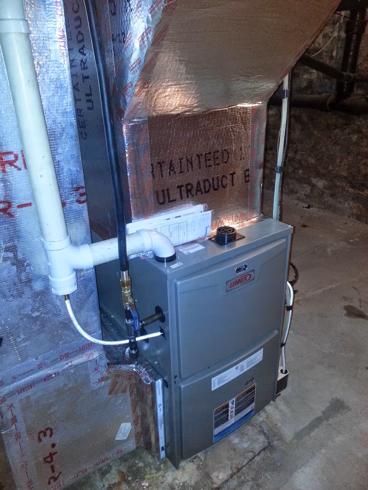 Basement utility room with Lennox furnace and exposed insulated ductwork.