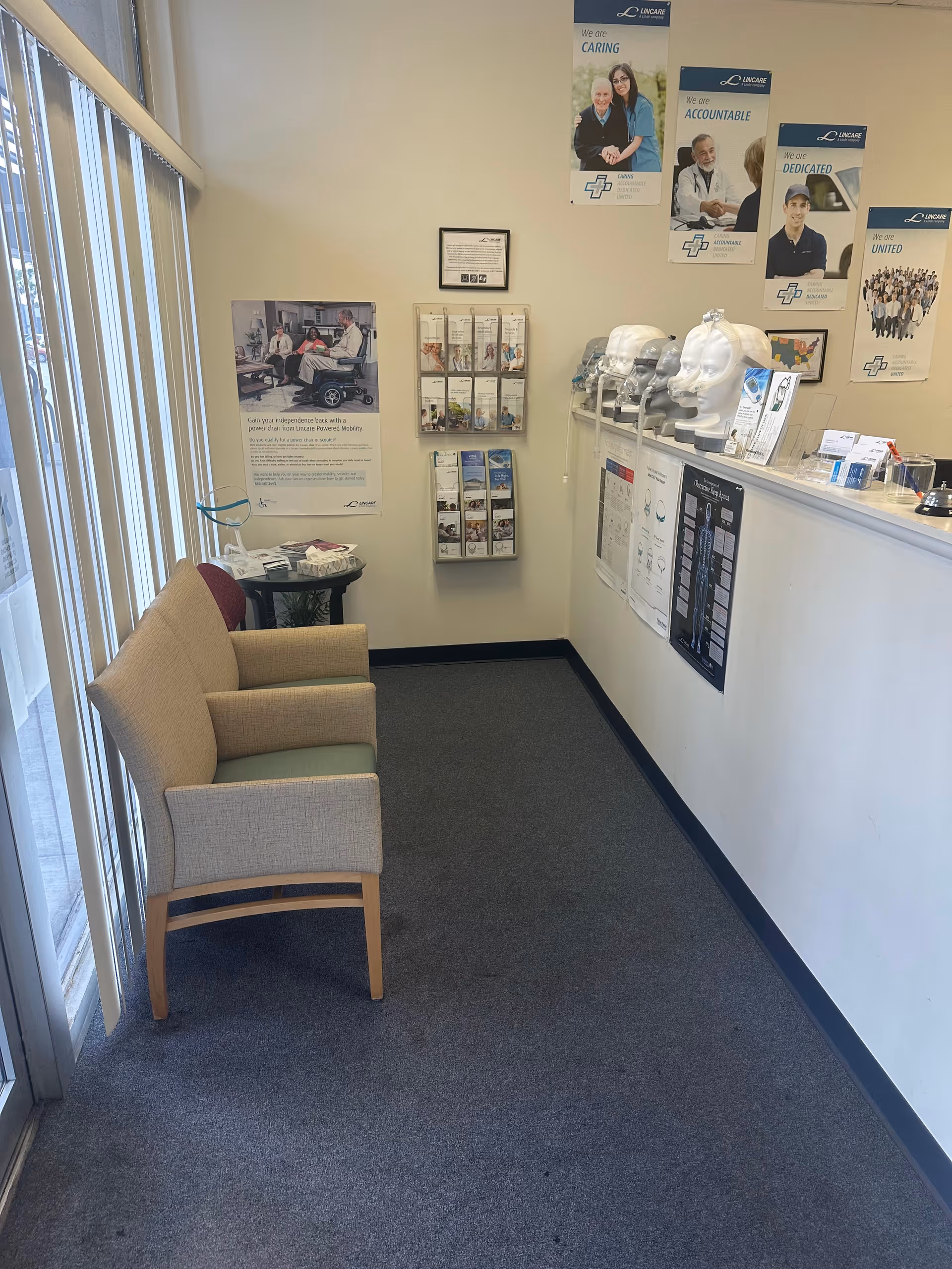 Interior waiting area with two beige chairs, brochures, and a front counter.