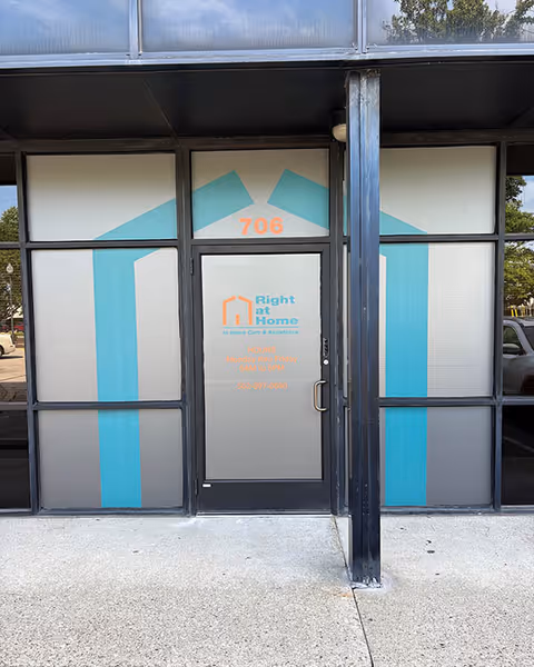 Glass storefront entrance for Right at Home with teal decorative panels and door.