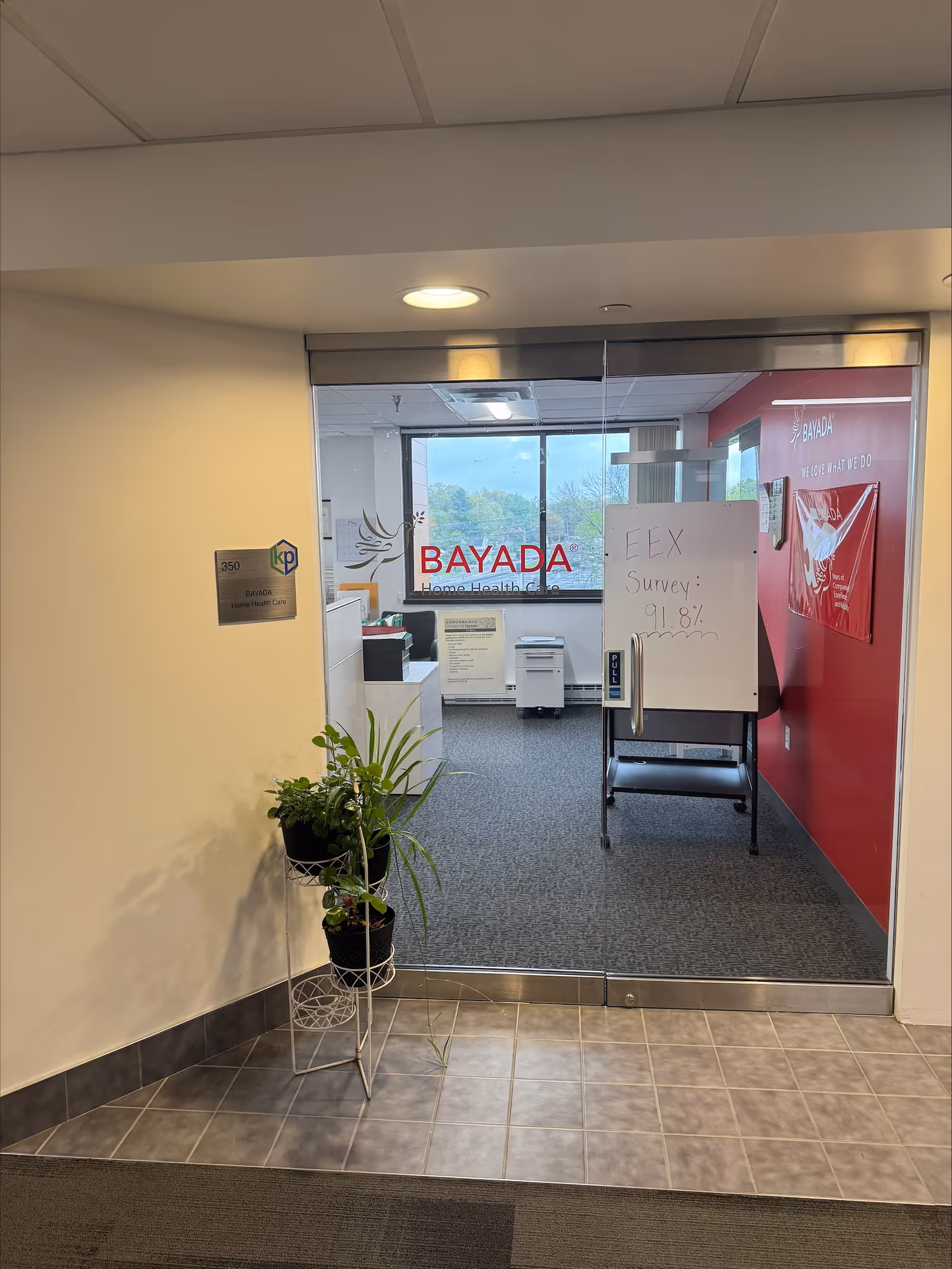 Office lobby featuring BAYADA branding, glass doorway, and potted plants