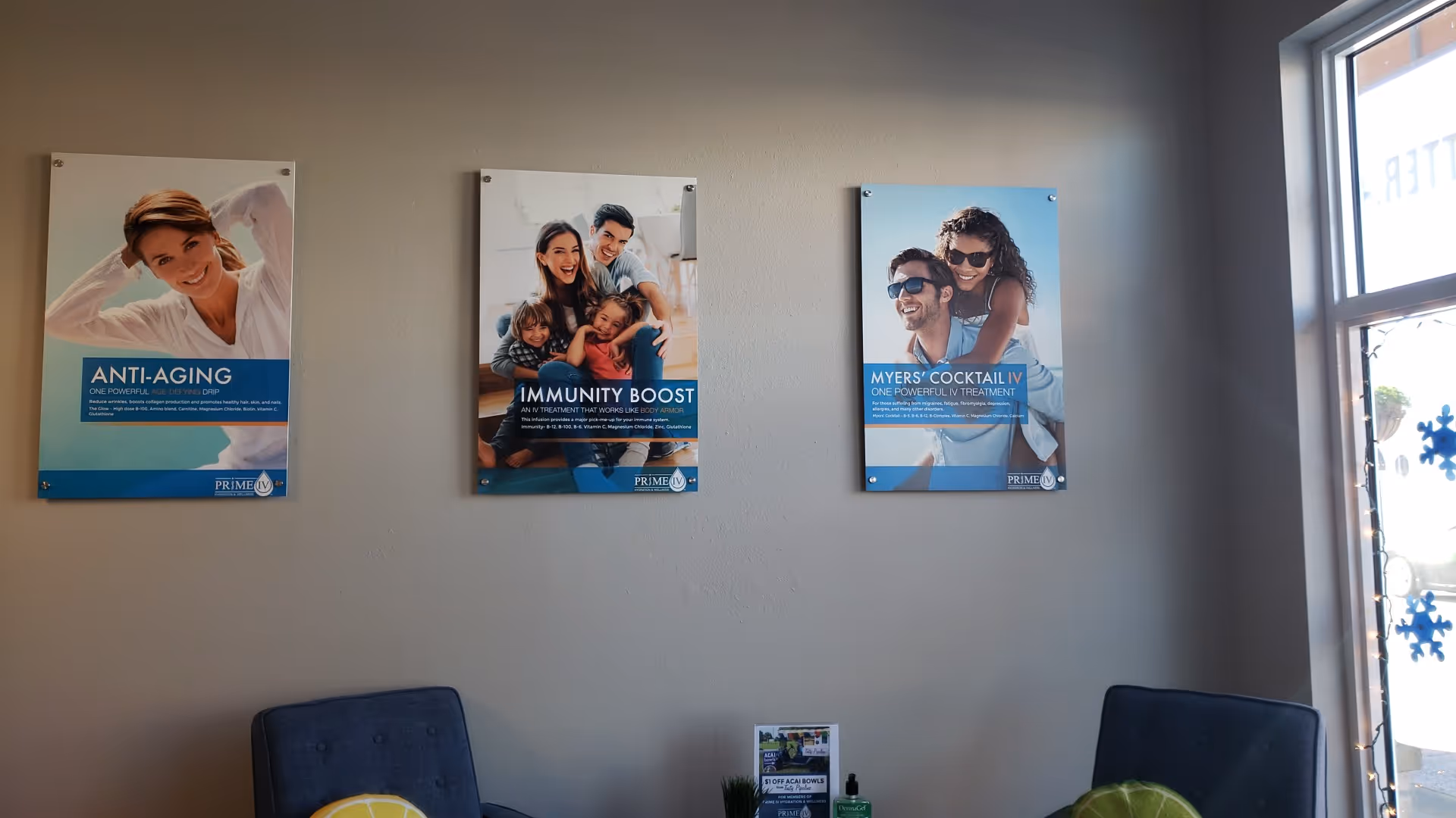 Interior waiting area with blue chairs and three promotional posters on the wall.