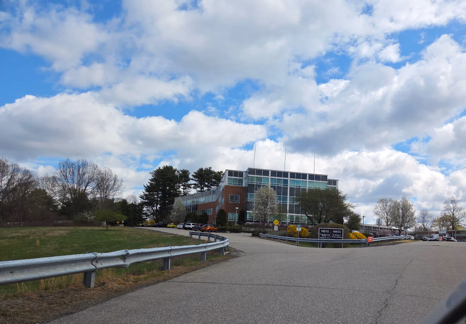 Exterior view of a modern senior care building with parking and blue sky