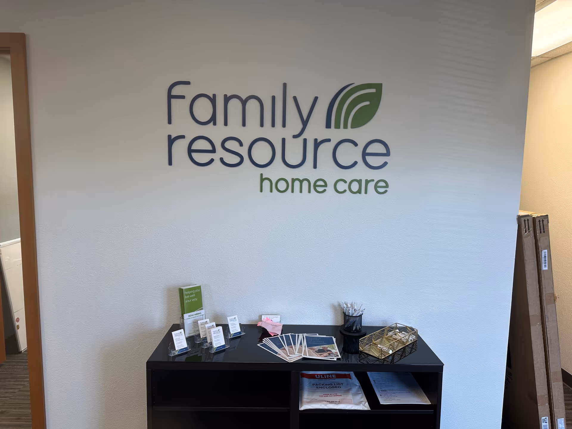 Interior wall features Family Resource Home Care sign above a brochure table.