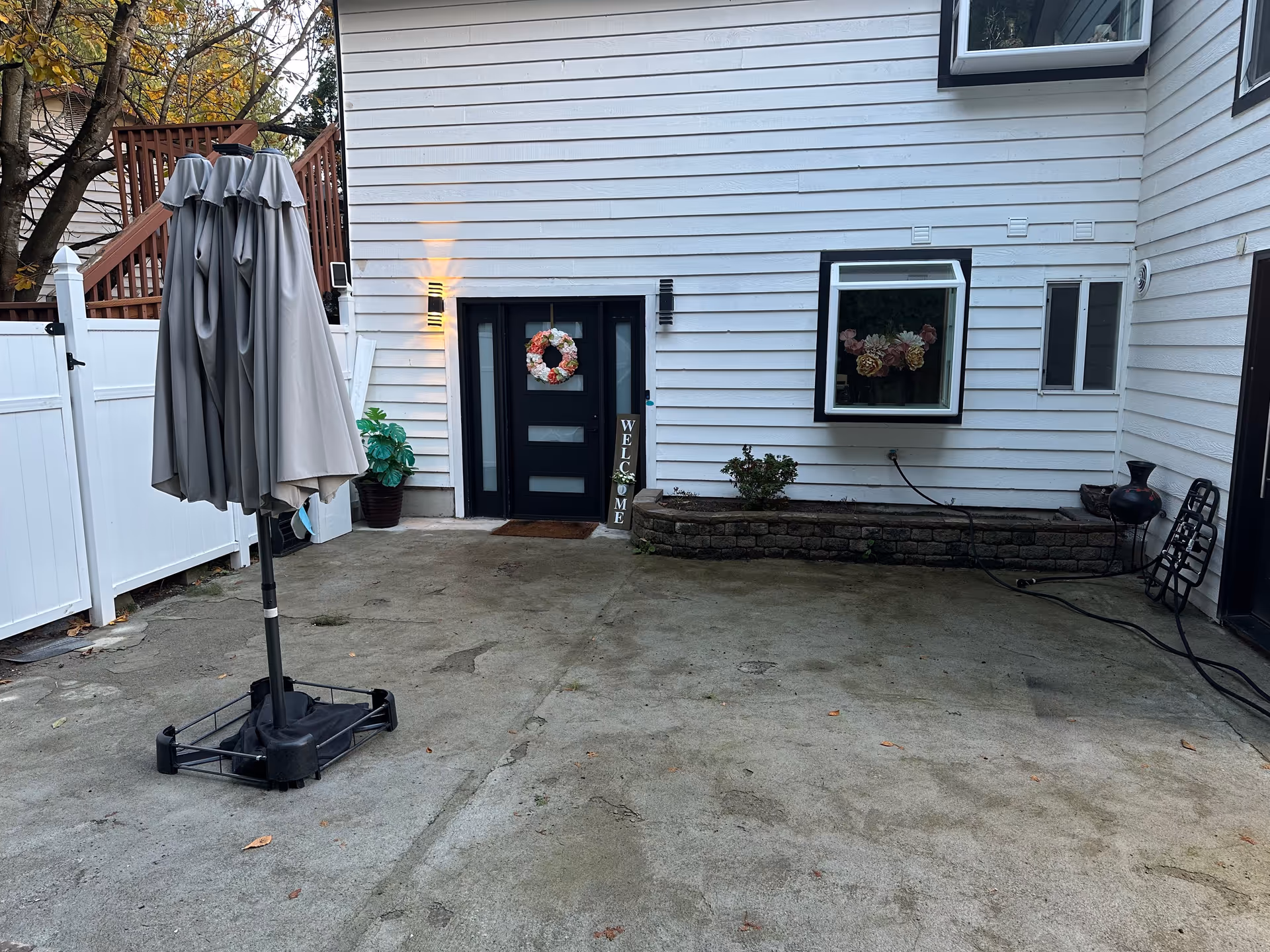 Backyard patio of a senior living facility with folded umbrella and wreath on the door.