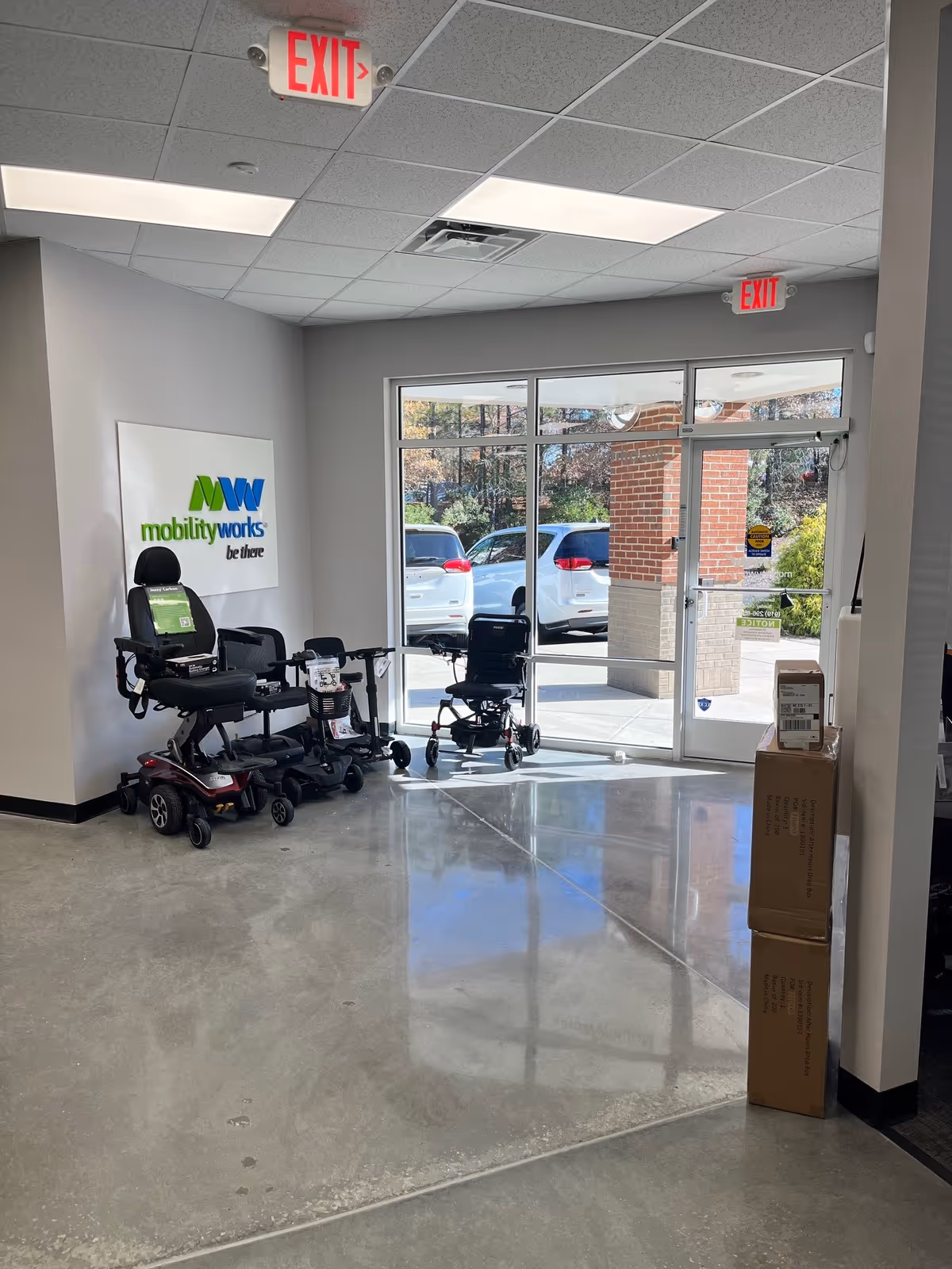 Interior lobby area with mobility scooters and wheelchairs near a MobilityWorks sign.