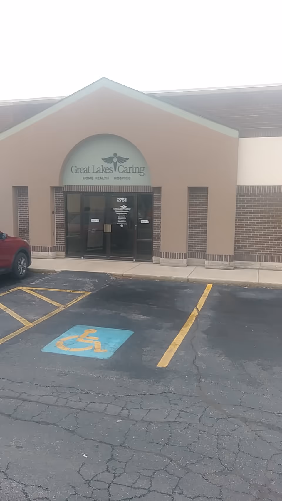 Front entrance of a senior care facility with a handicapped parking space in view.