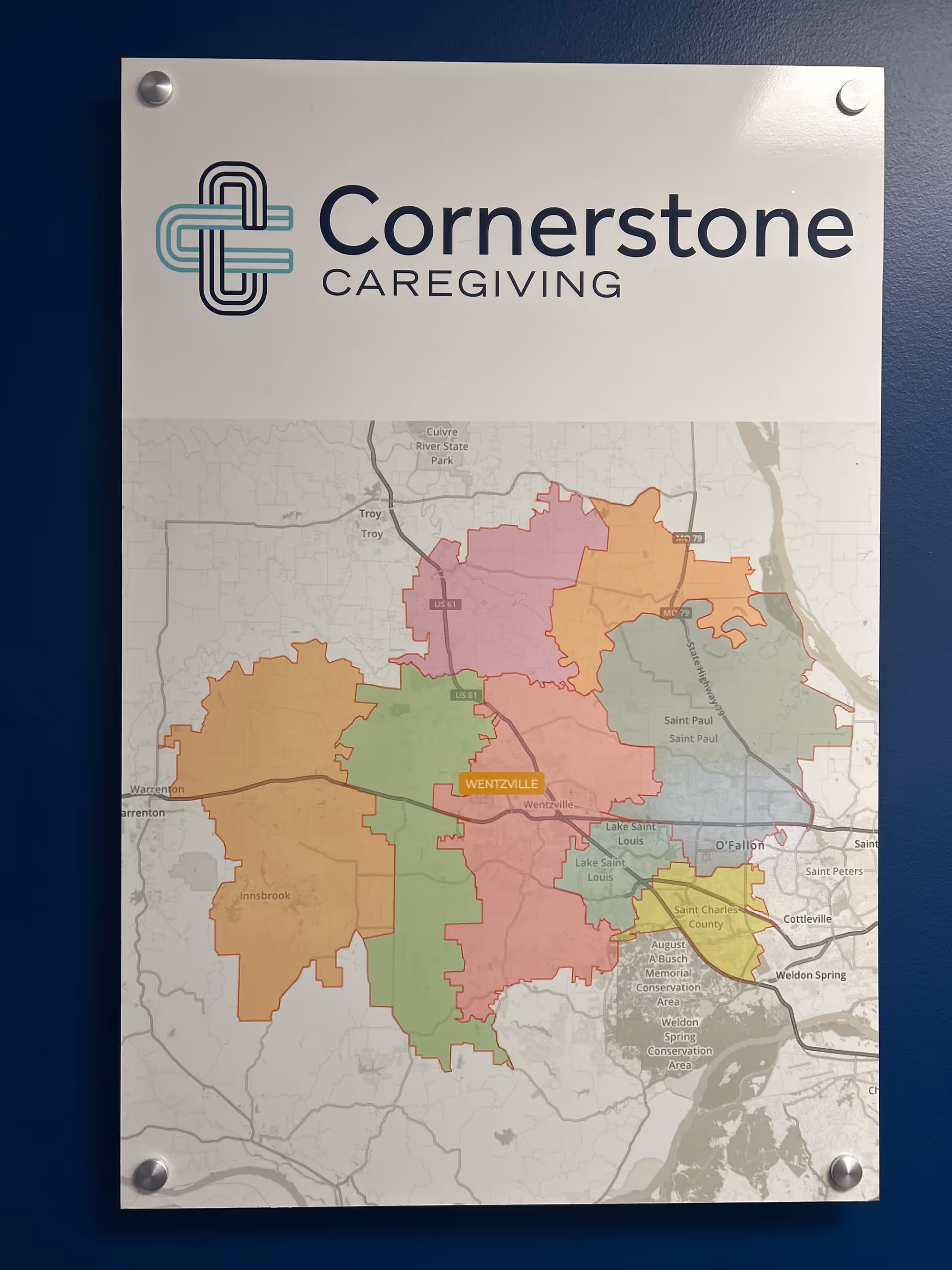 Interior wall sign displaying Cornerstone Caregiving logo and a large color map.