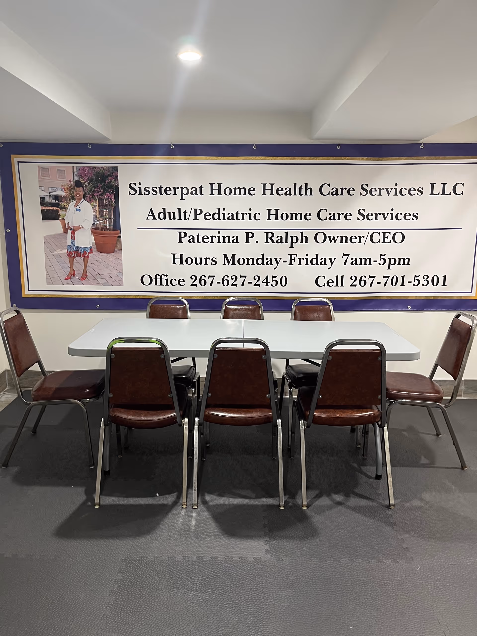Meeting room with a large banner and brown chairs around a white table.