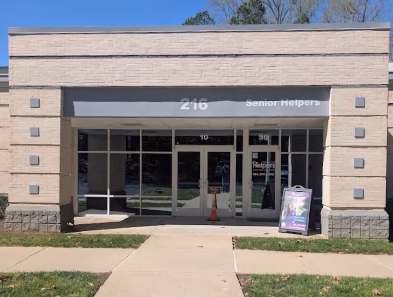Front of a Senior Helpers facility with glass doors and a sidewalk entry.