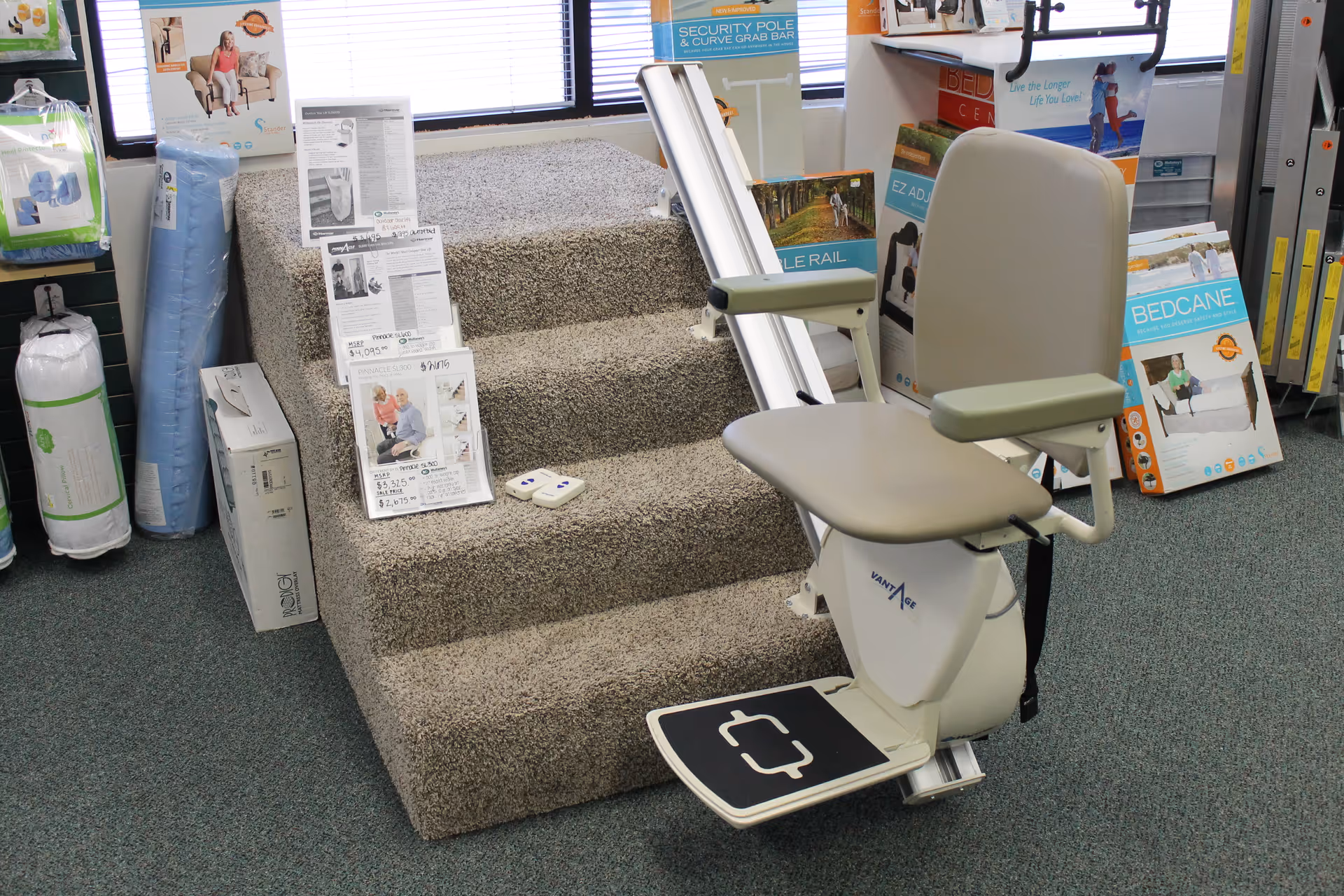 Indoor display of a stair lift chair beside carpeted steps and brochures.