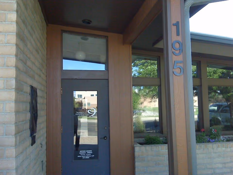 Exterior entrance to HopeWest Administrative Offices with glass door and 195 on column.