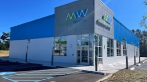 Exterior view of MobilityWorks building with a blue facade and accessible parking.