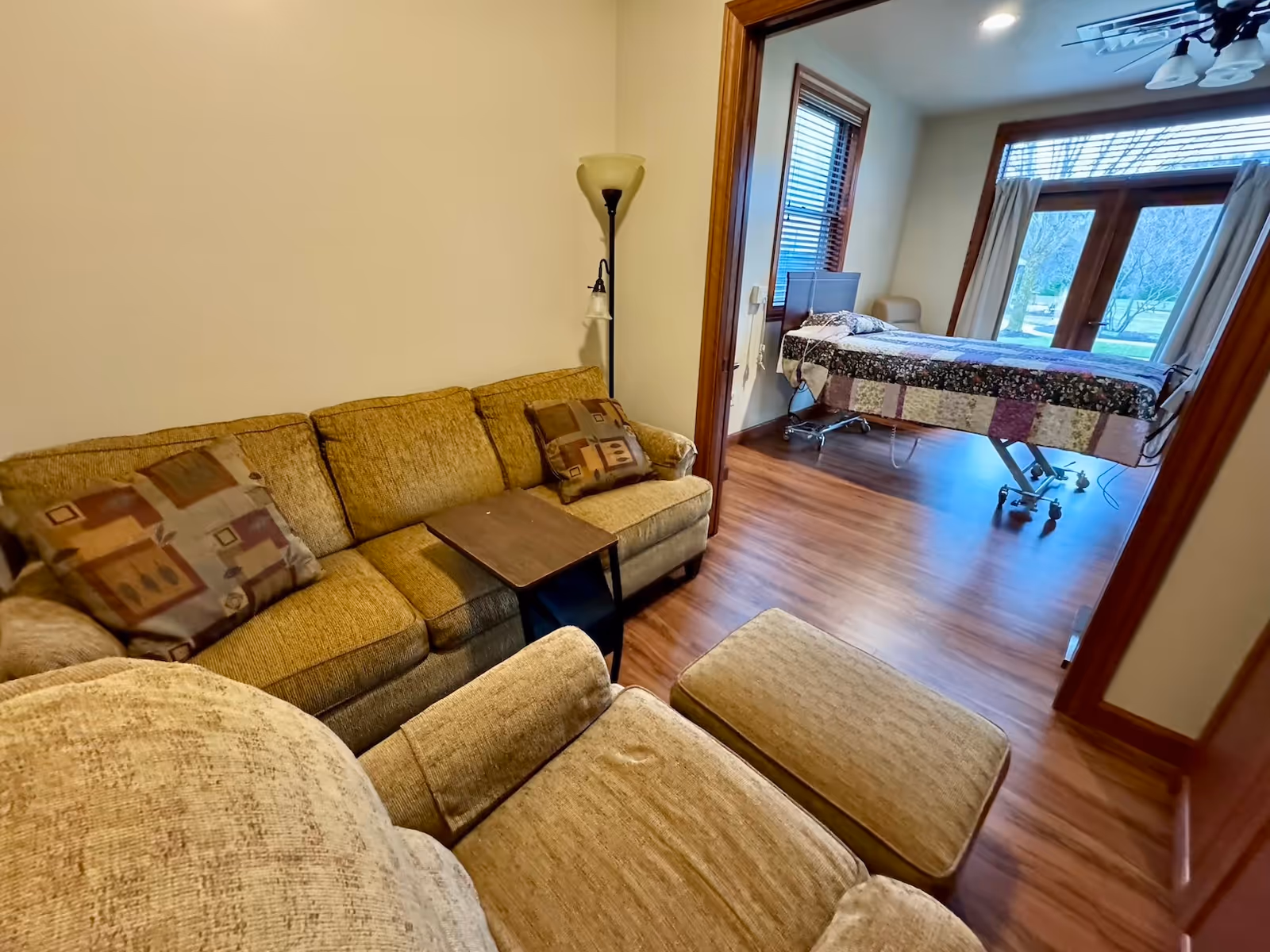Cozy beige living room with sofa and ottoman, doorway to patient room.