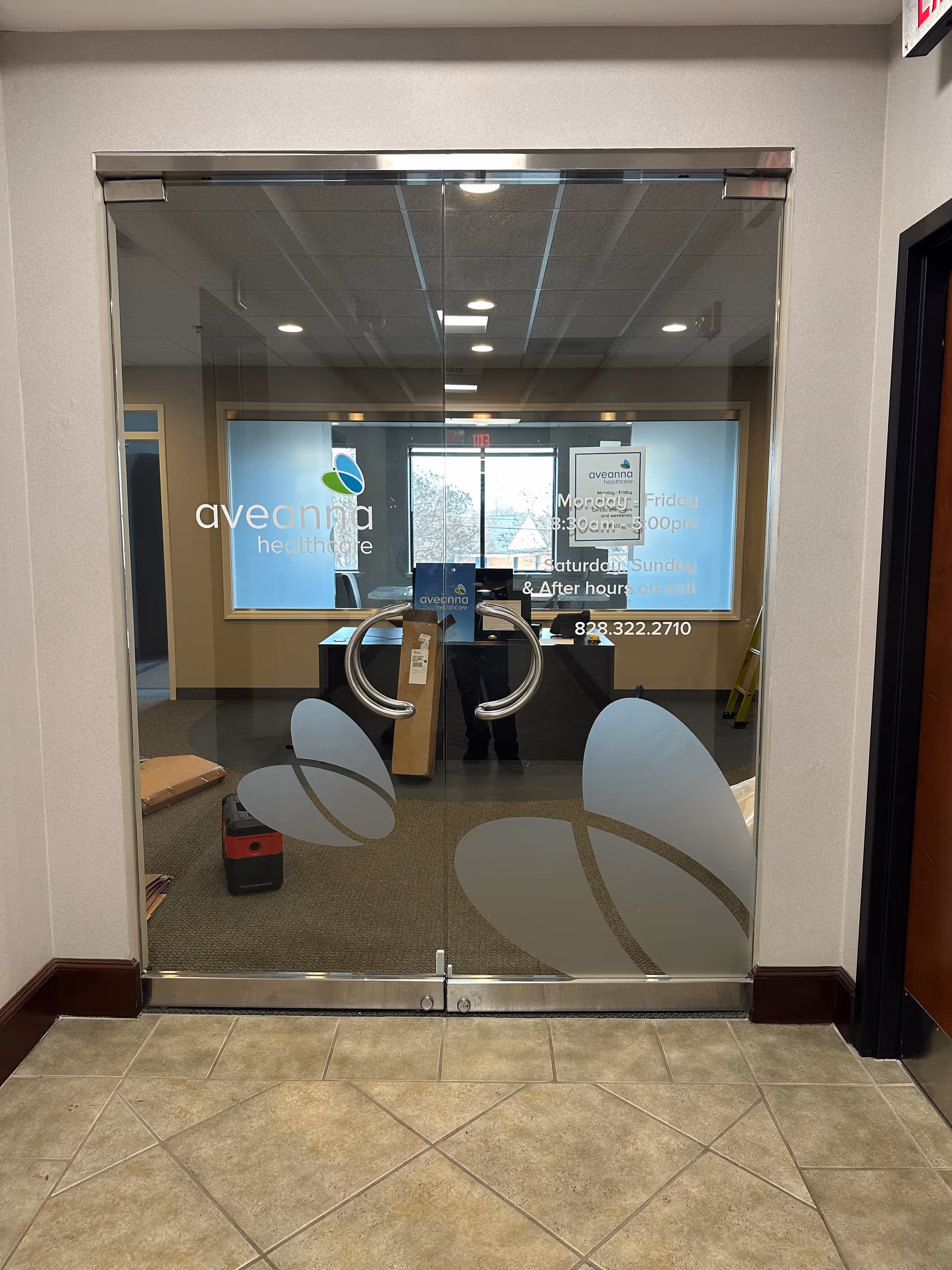 Glass entry doors to Aveanna Healthcare lobby with reception desk inside.