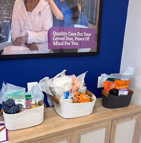 Three baskets of care items on a wooden counter in front of a blue wall.