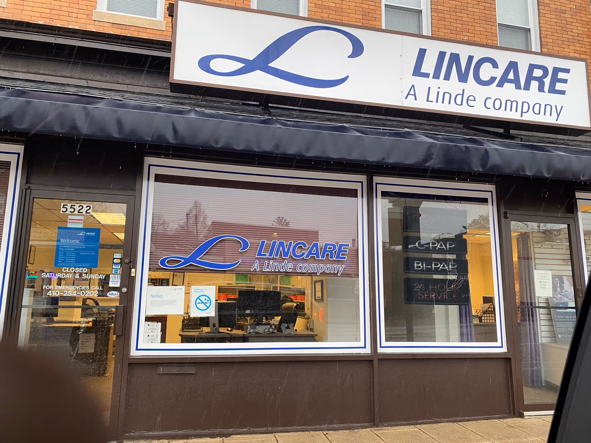 Storefront with LINCARE sign on brick building and large display windows.
