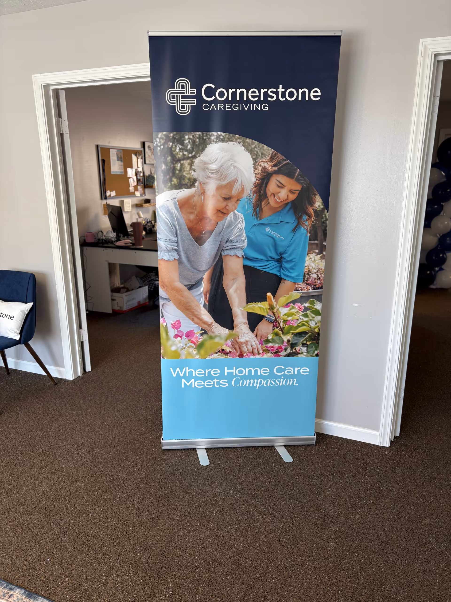 Banner featuring two people and Cornerstone Caregiving logo in a hallway interior.