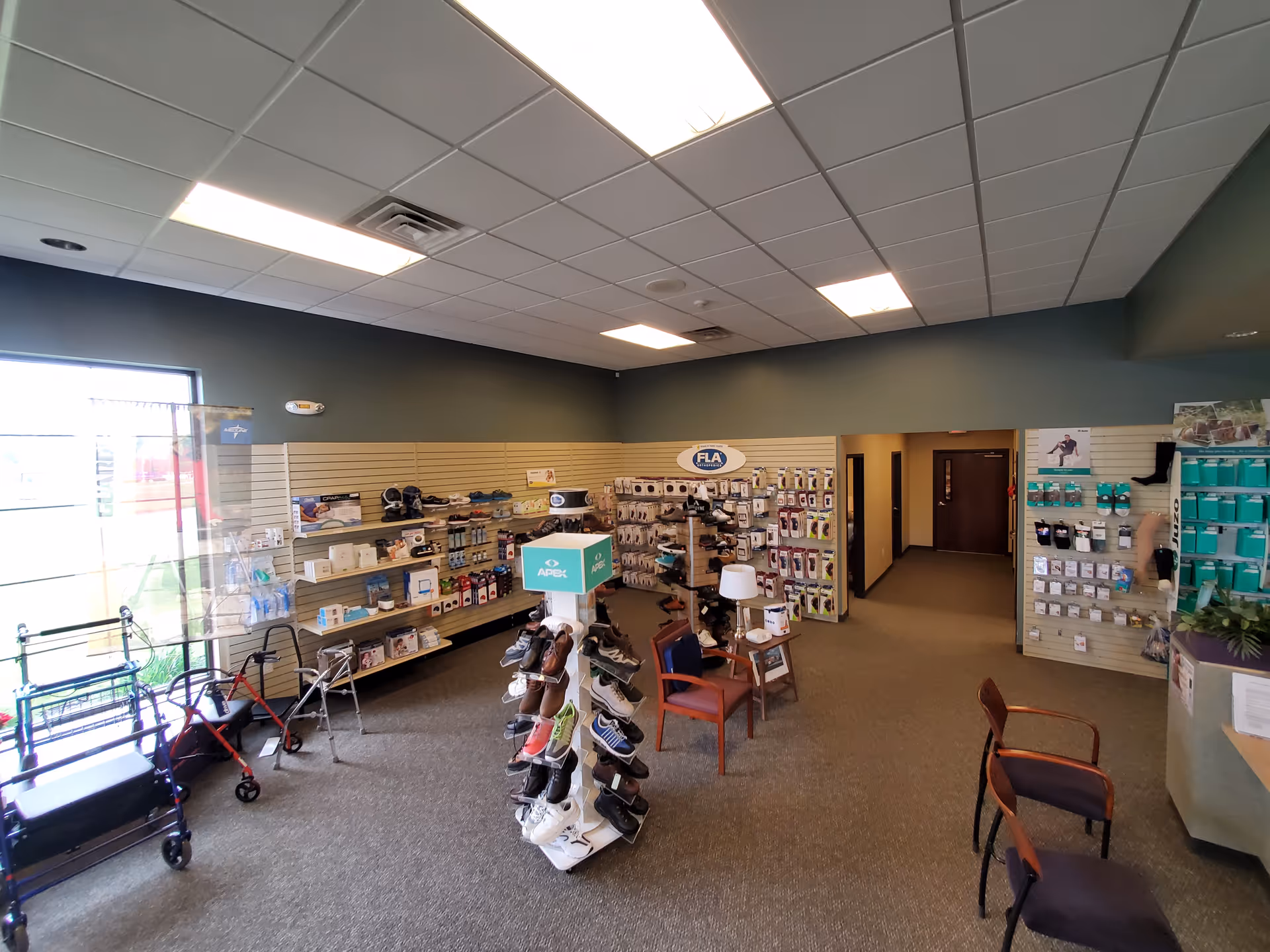 Interior view of Alick's Home Medical store area with shelves and chairs.