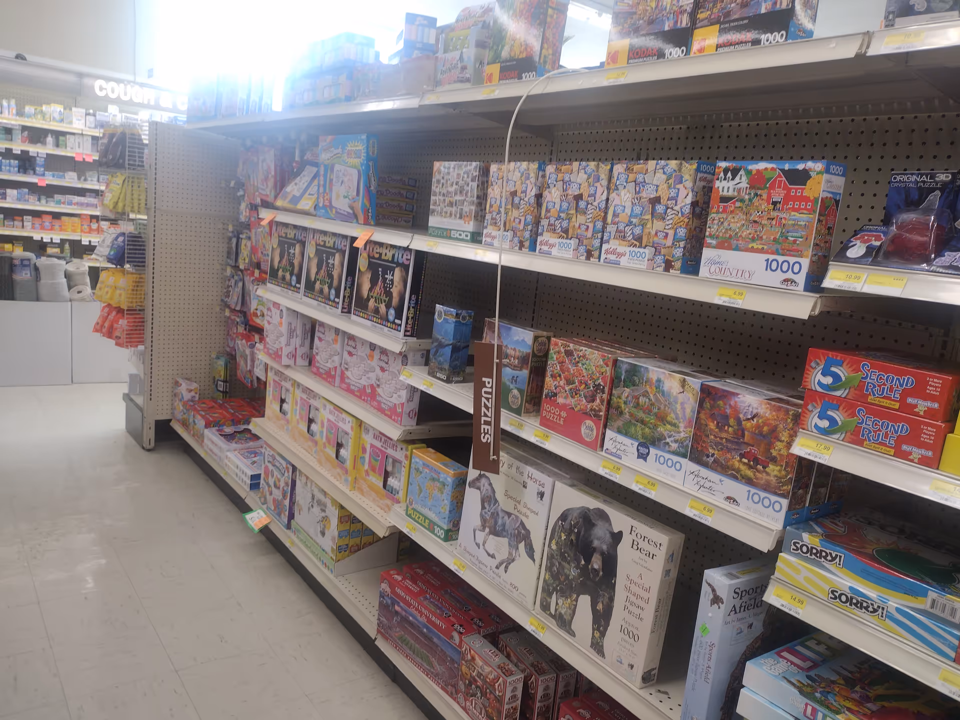 An interior Discount Drug Mart aisle filled with puzzle boxes on shelves.