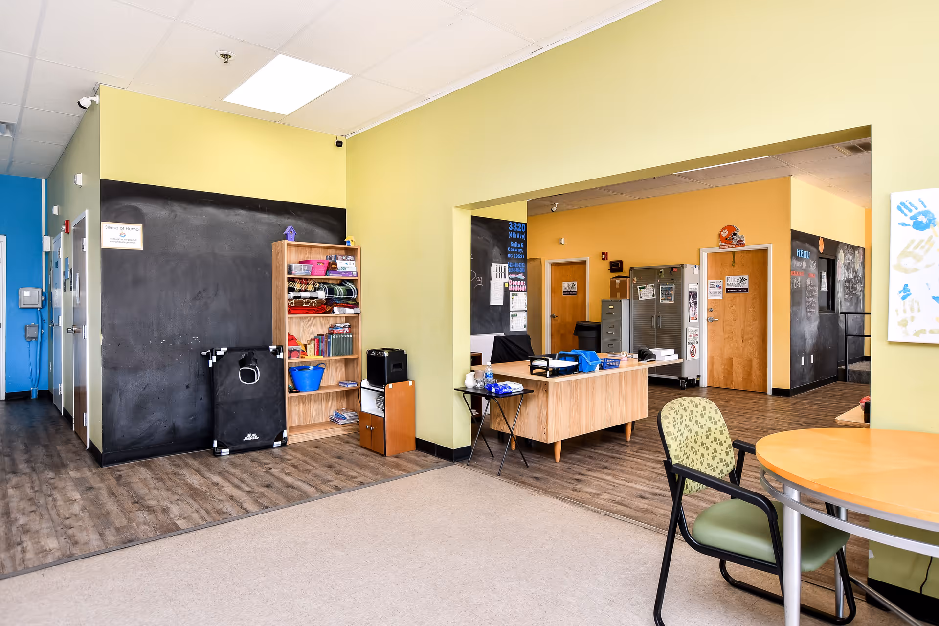 Bright lobby of Elite Home Care and Day Centers with reception desk, seating, and chalkboard walls.