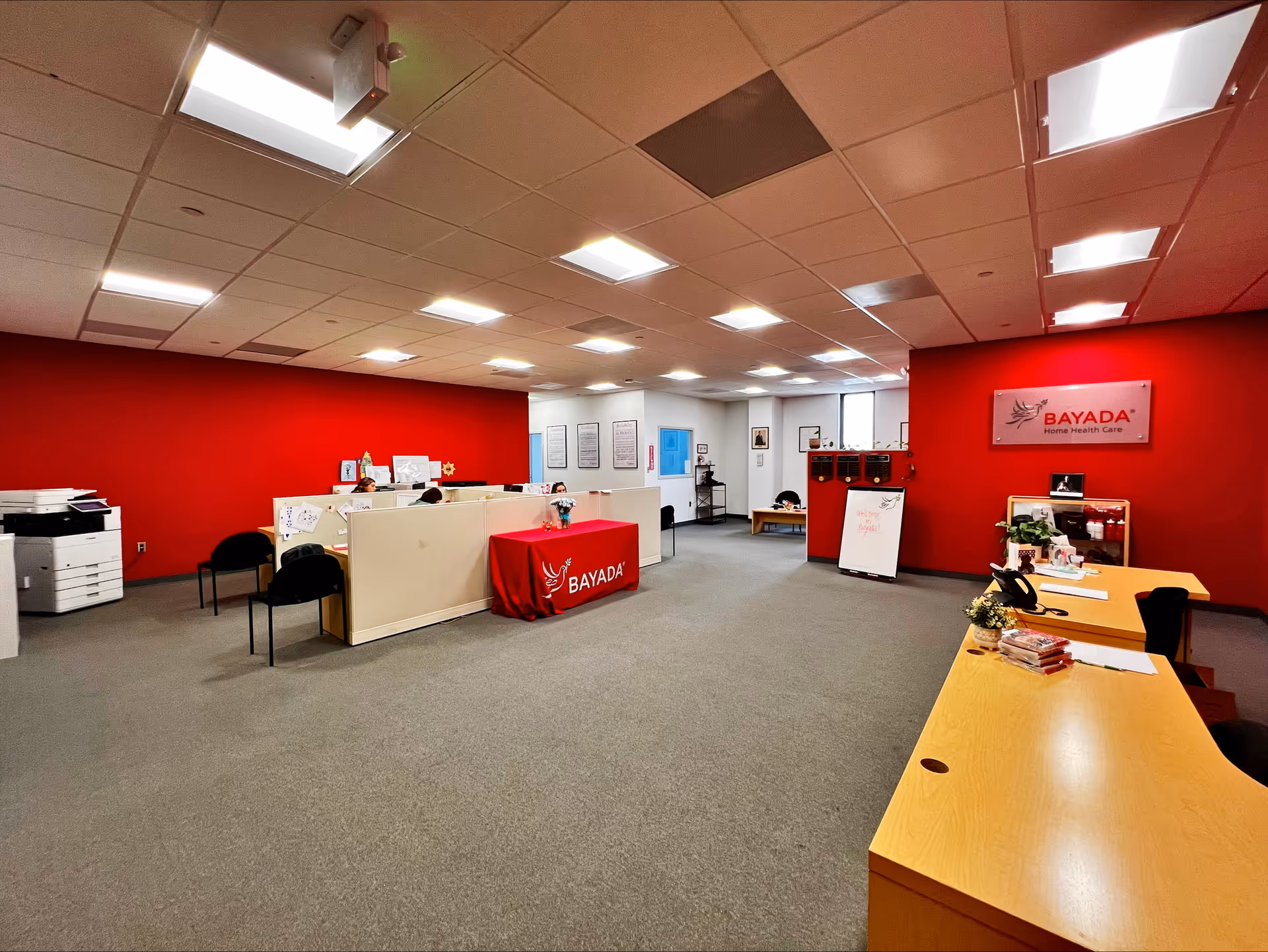 Reception area inside BAYADA Assistive Care with red walls and a front desk.